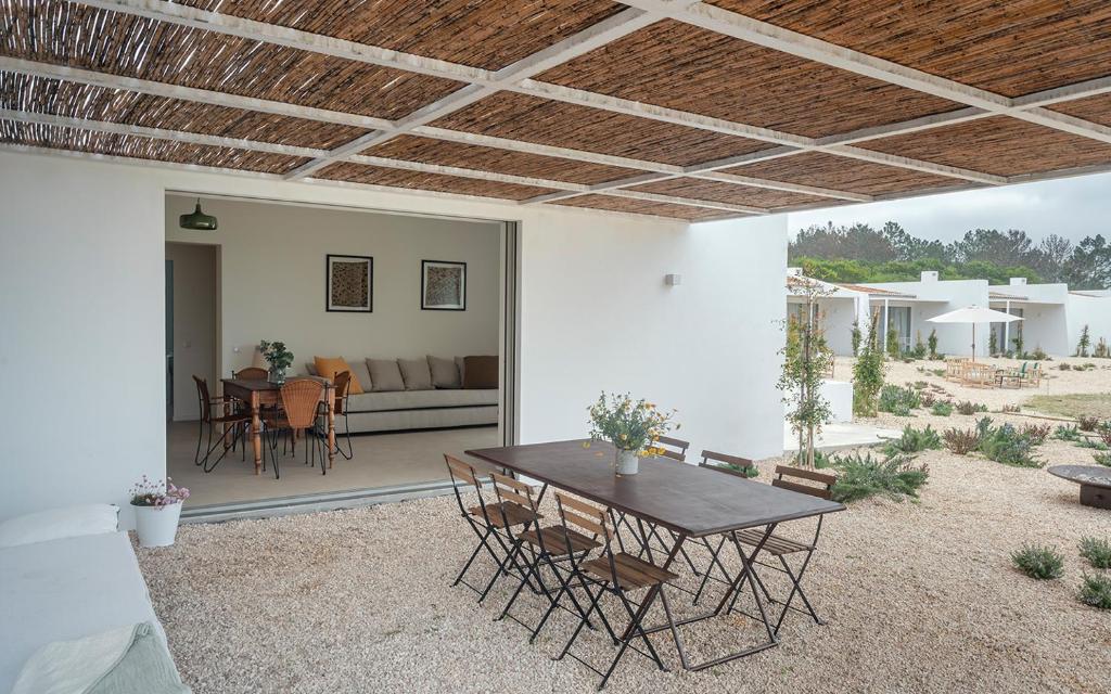 a patio with a table and chairs and a couch at Amaria in Aljezur
