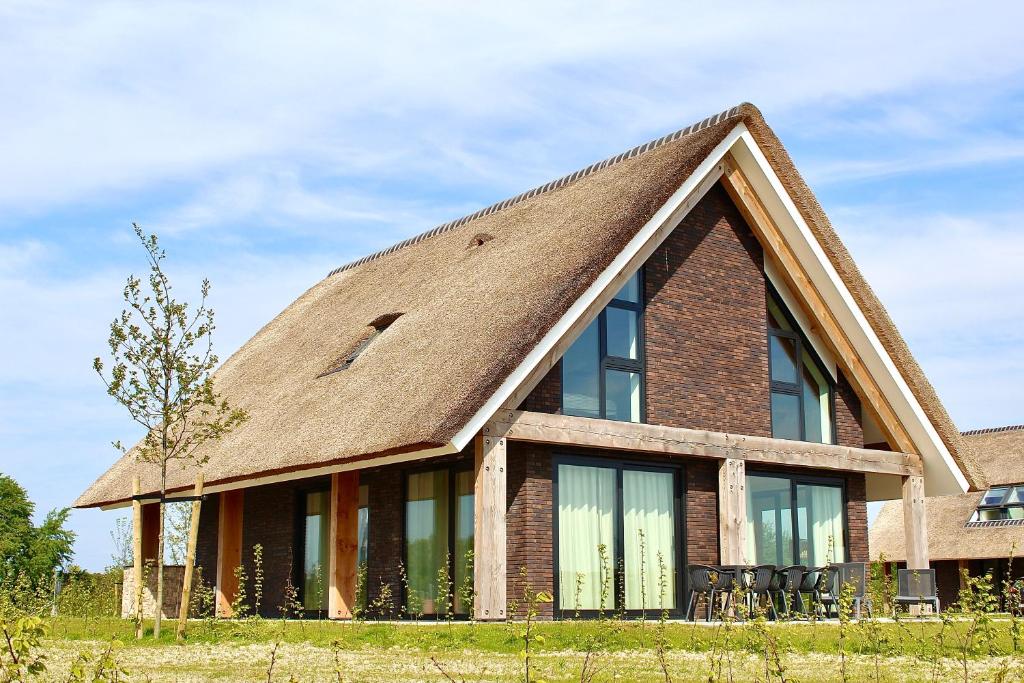 Bild eines Hauses mit Strohdach in der Unterkunft Zandbank Villa's in Vrouwenpolder