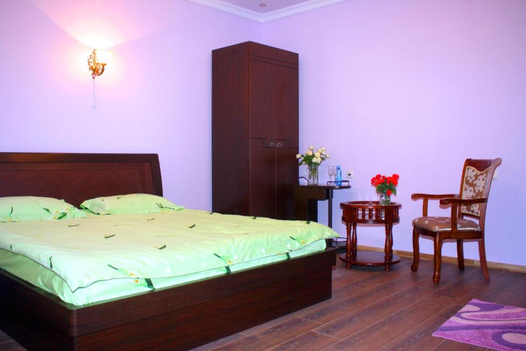 a bedroom with a bed and a chair and a table at Christy Hotel in Goris