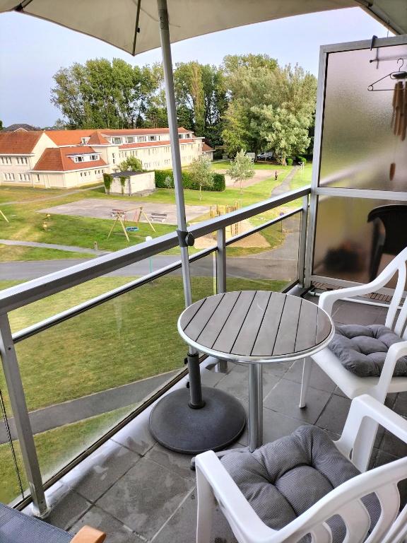 eine Terrasse mit Tisch und Stühlen auf einem Balkon in der Unterkunft Silver Lotus in De Haan