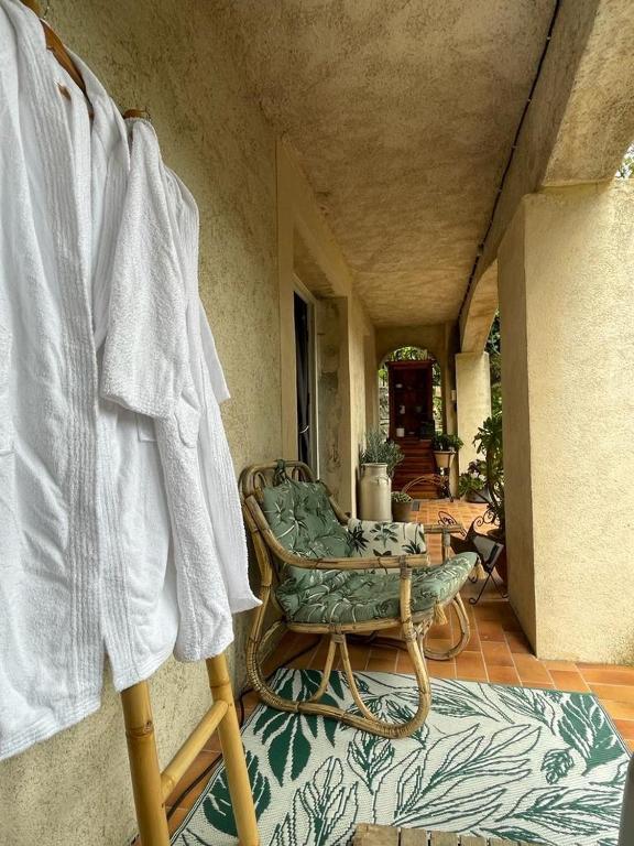 a room with a couch and a chair on a porch at Gite du Prinas in Gréolières