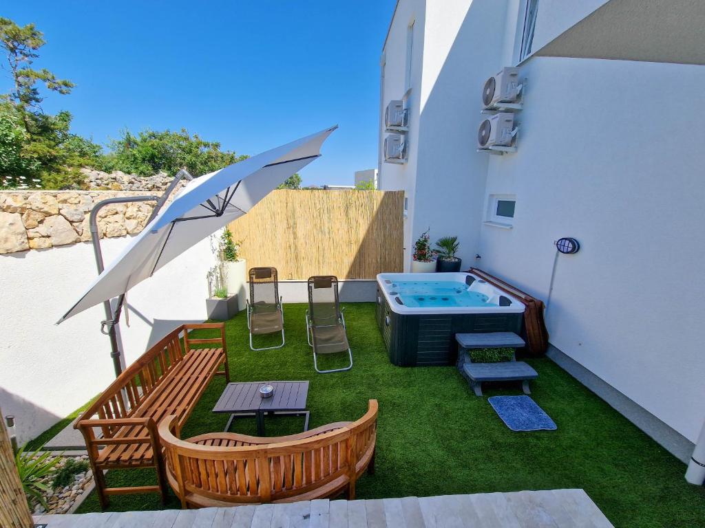 a small backyard with a pool and chairs and a table at Villa AISHA with private jacuzzi in Novalja