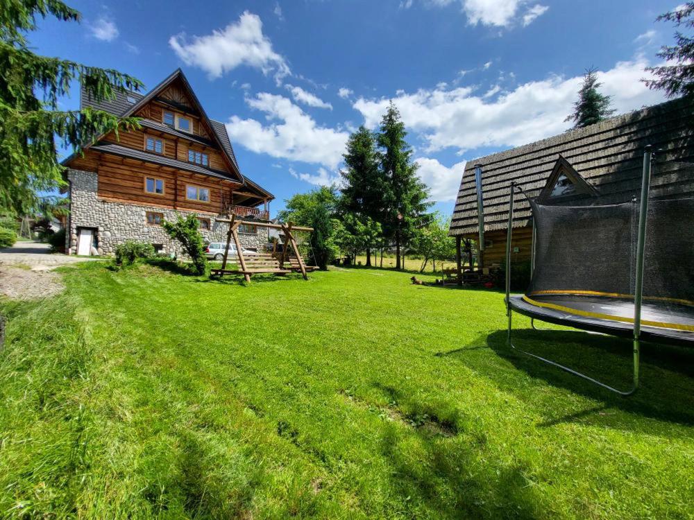 a large yard with a house and a swing at Domek Góralki in Zakopane