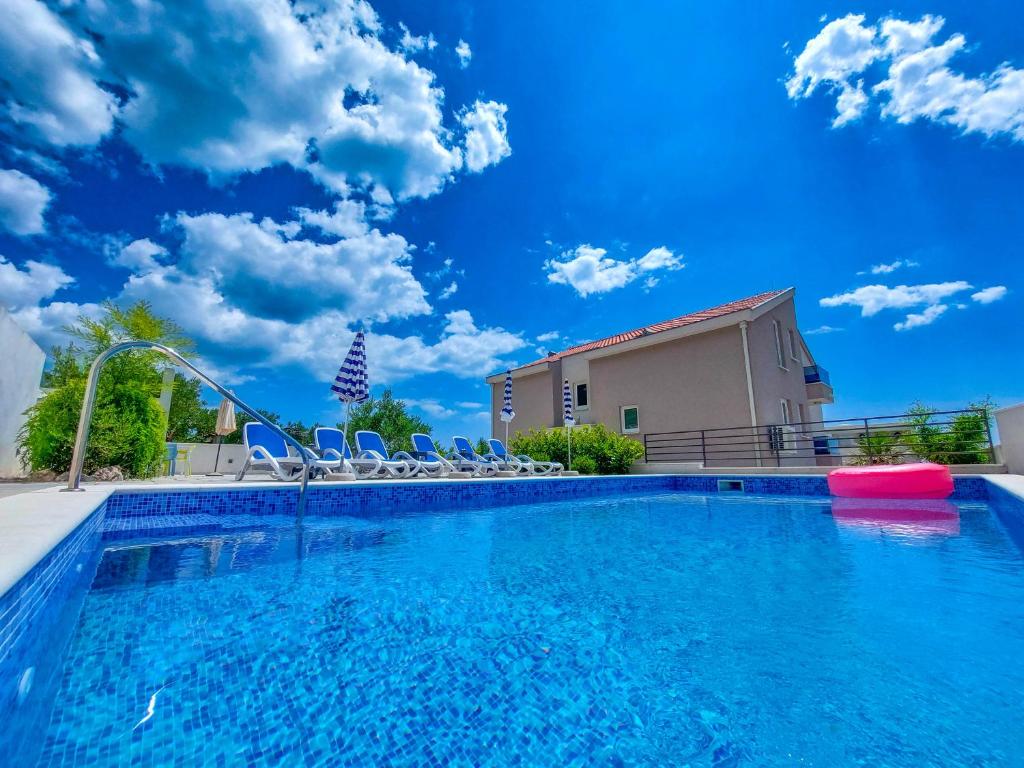 馬卡爾斯卡的住宿－Holiday Home Ferias，一个带椅子和滑梯的游泳池
