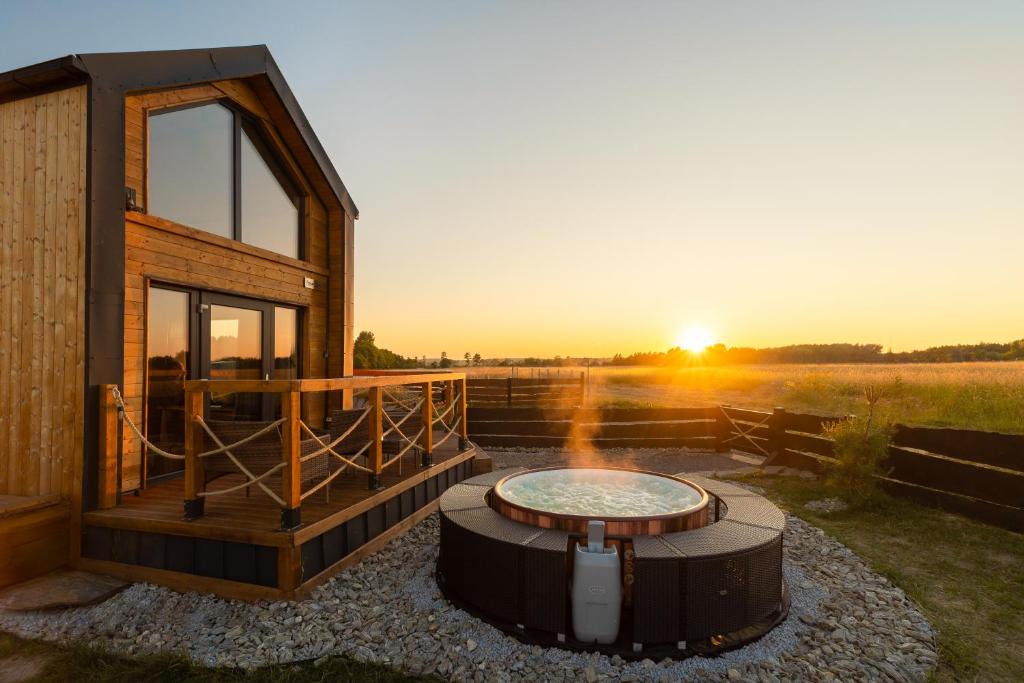 a cabin with a fire pit and the sunset in the background at Your Holidays Freedom in Zastań