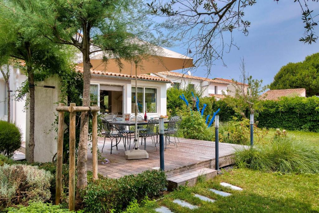 une terrasse en bois devant une maison dans l'établissement La Flotte - 10 Personnes - 800m du centre, à La Flotte