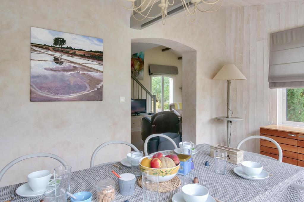 a dining room table with a bowl of fruit on it at Havre de paix pour 10 a l Ile de Re in La Flotte