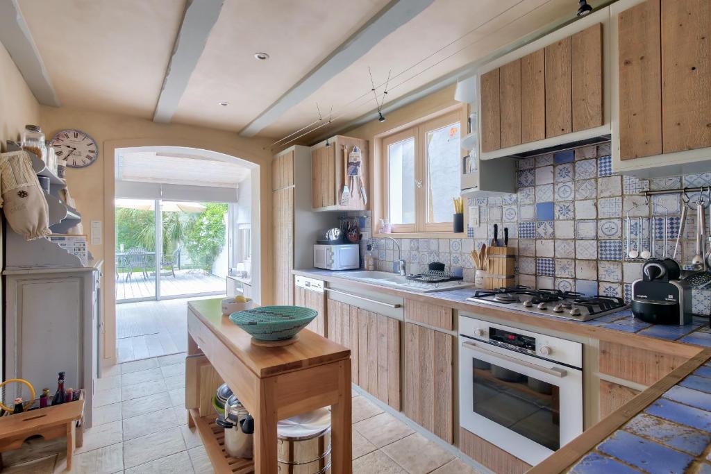 a kitchen with wooden cabinets and a counter top at Havre de paix pour 10 a l Ile de Re in La Flotte