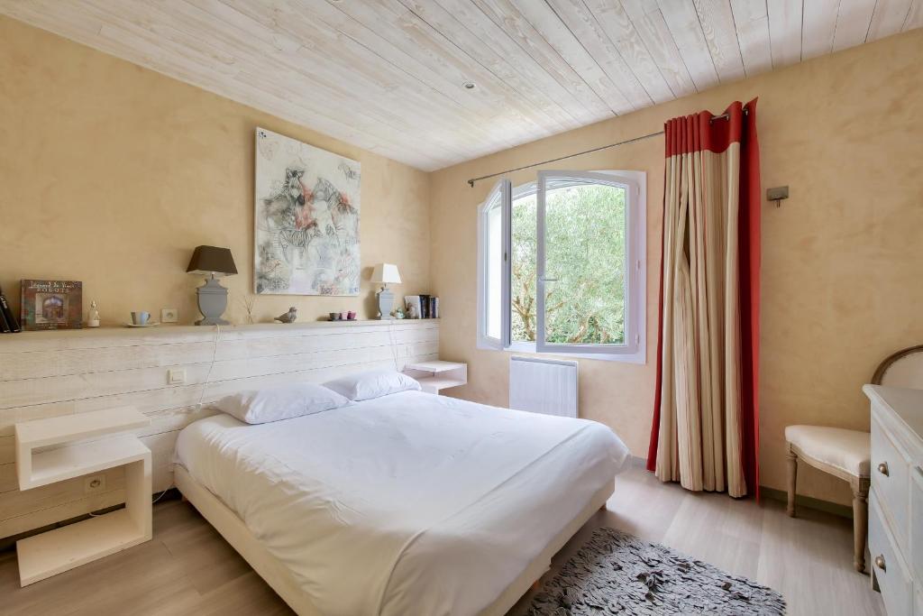 a bedroom with a white bed and a window at Havre de paix pour 10 a l Ile de Re in La Flotte