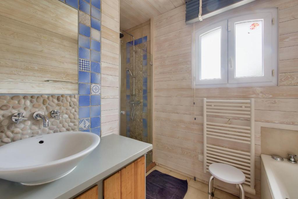 a bathroom with a white sink and a tub at Havre de paix pour 10 a l Ile de Re in La Flotte