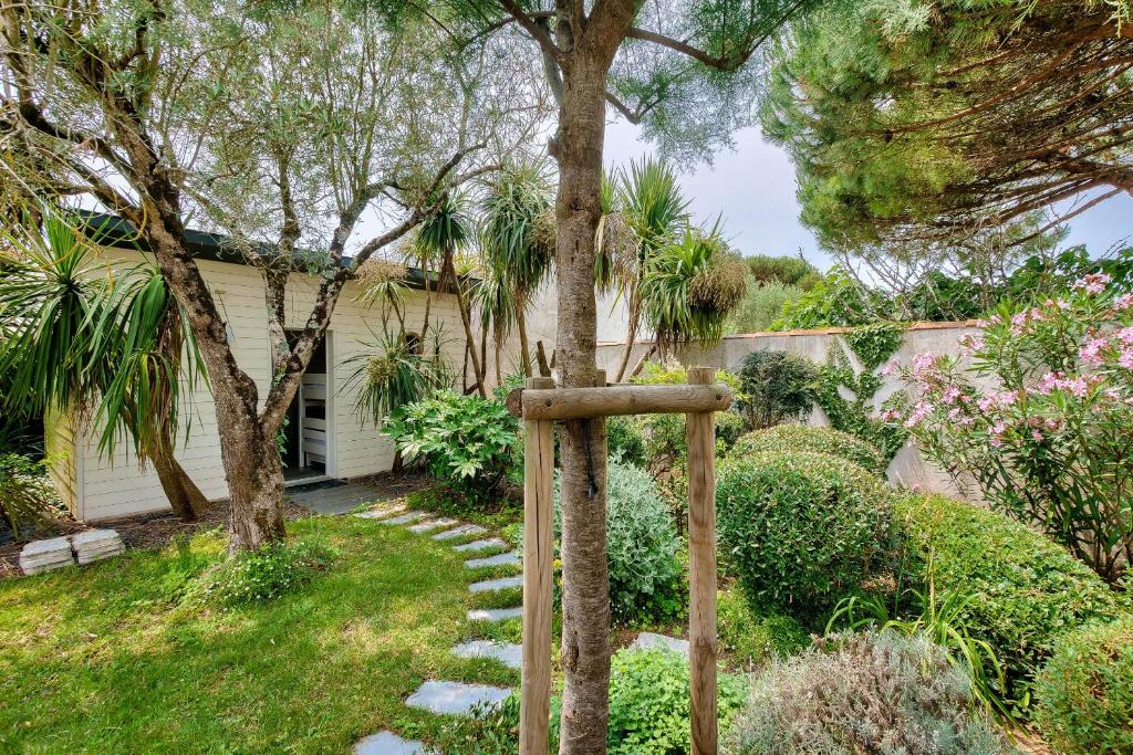 a garden with a stone cross in front of a house at Havre de paix pour 10 a l Ile de Re in La Flotte