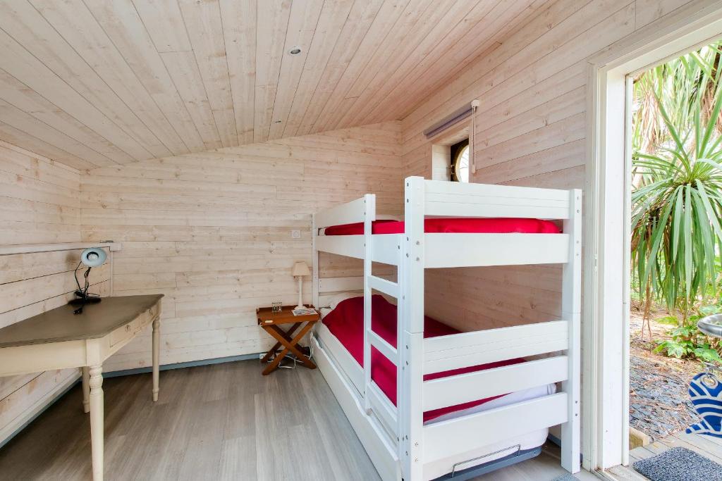 a bedroom with two bunk beds and a desk at Havre de paix pour 10 a l Ile de Re in La Flotte
