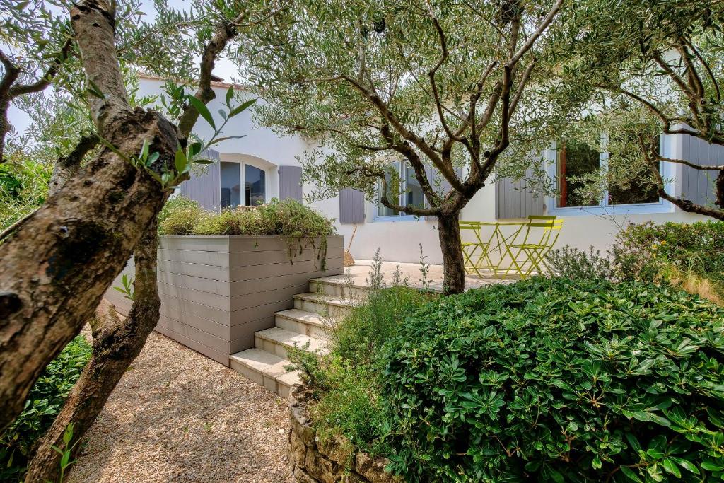 a house with stairs and trees in front of it at Havre de paix pour 10 a l Ile de Re in La Flotte