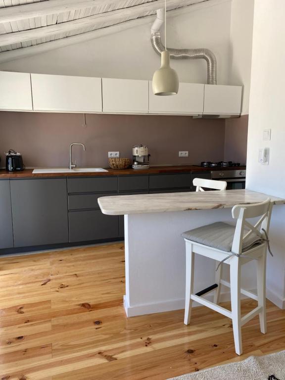 a kitchen with a white counter and a table at Casa Figo - Aljezur old town in Aljezur