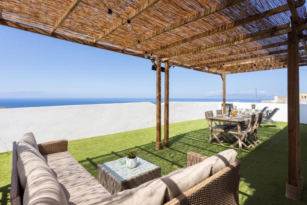 un patio con mesa y sillas y vistas a la playa en Acogedor Apartamento con vistas al mar en Costa Adeje en Adeje