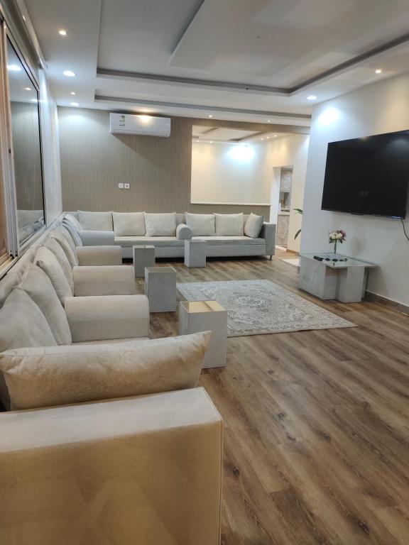 a living room with couches and a flat screen tv at شاليه البستان حي المنتزه الغربي in Hail