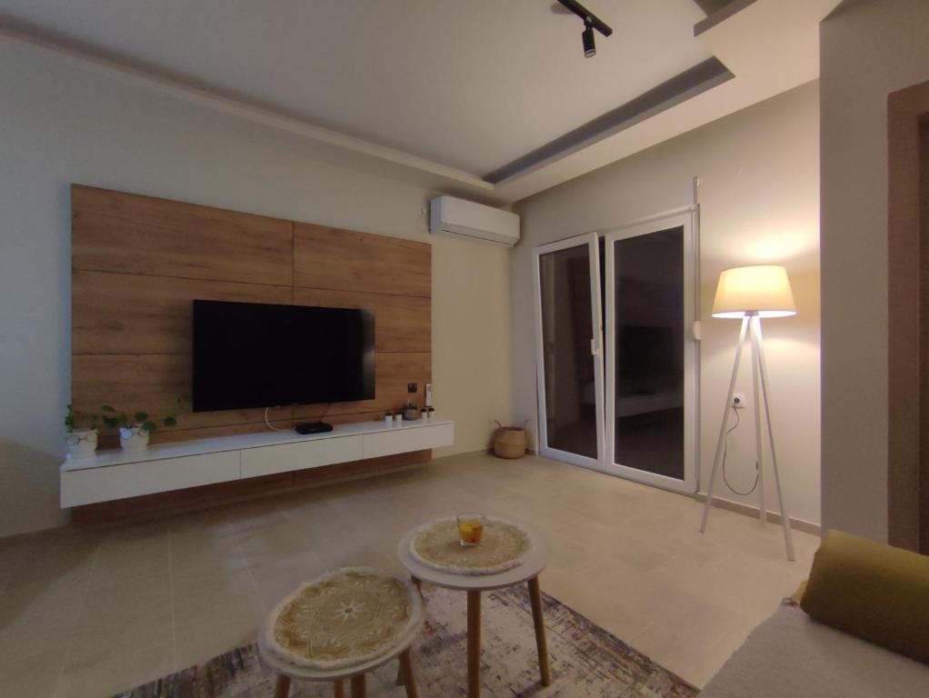 a living room with a flat screen tv on a wall at Apartman Front in Šid