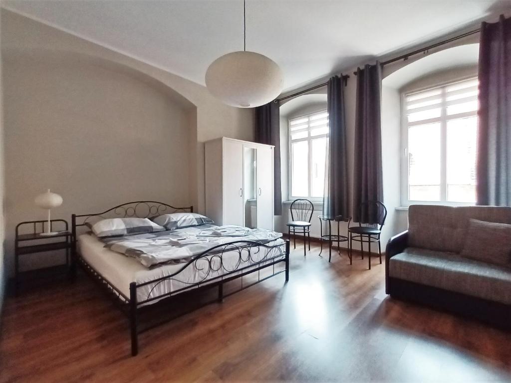 - une chambre avec un lit et un canapé dans l'établissement Apartament Majówka w Karkonoszach, à Kowary