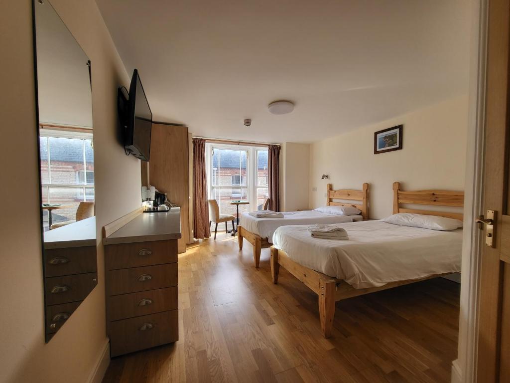 a hotel room with two beds and a television at The Grand Harbour hotel in Ilfracombe