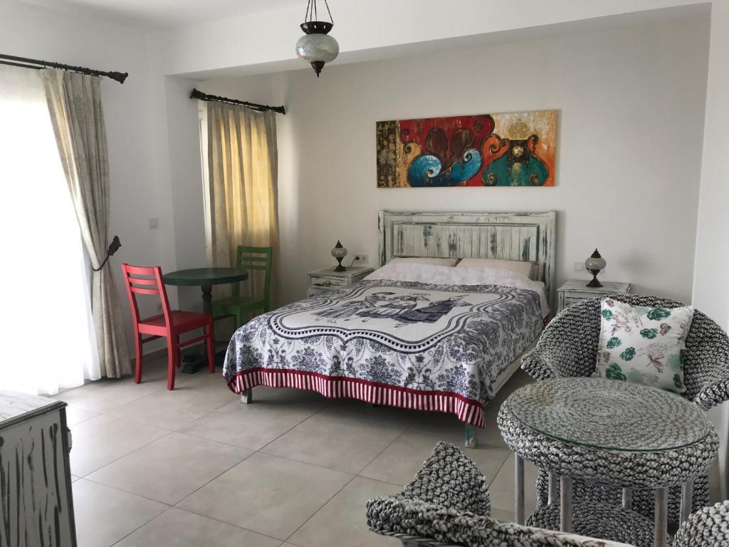a bedroom with a bed and a table and a chair at Bahama Art Hotel in Turgutreis