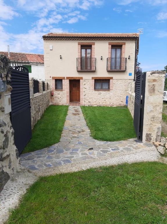 a house with a gate in front of a yard at LA PORTADA DE ABAJO in Gallegos