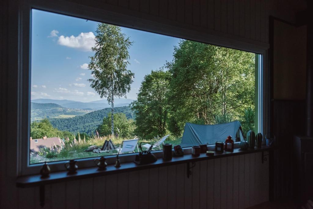 uma janela com vista para uma tenda e para as montanhas em RESETówka - chatka na odludziu do wynajęcia em Jaszczurowa