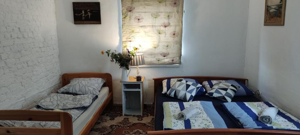 1 dormitorio con 2 camas y mesa con lámpara en Dom Podróżnika -aktywne wakacje, en Jabłonowo