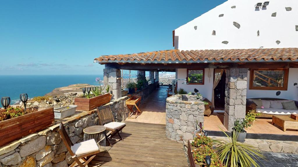 una casa con terraza de madera junto al océano en Luxury Colonial Country Villa, en Moya