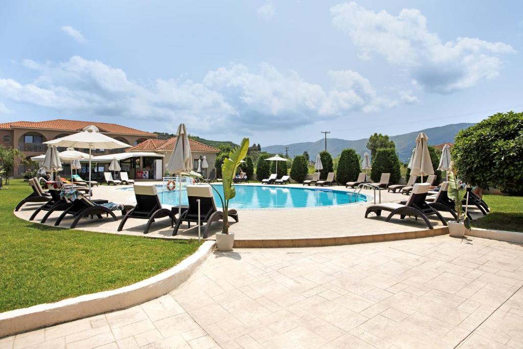 a pool with chairs and tables and umbrellas at Eleni's Garden 3 in Alikanas