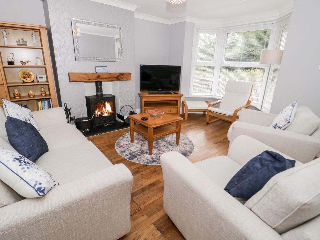 a living room with two couches and a fireplace at 1 River View Terrace in Llandudno Junction