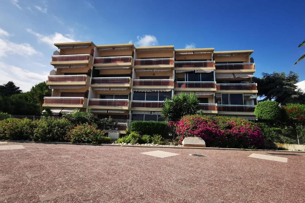 a tall apartment building with a parking lot in front of it at Charming air-conditioned studio &quot;Diarama&quot; with sea view and parking in Saint-Laurent-du-Var