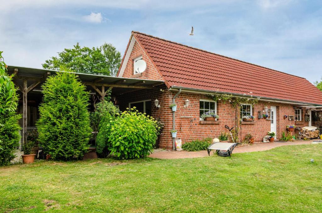 a brick house with a bench in the yard at Möwchen in Berumbur