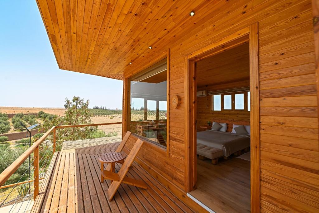 Cabina in legno con letto e sedia sul ponte di Le Parc des Oliviers a Marrakech