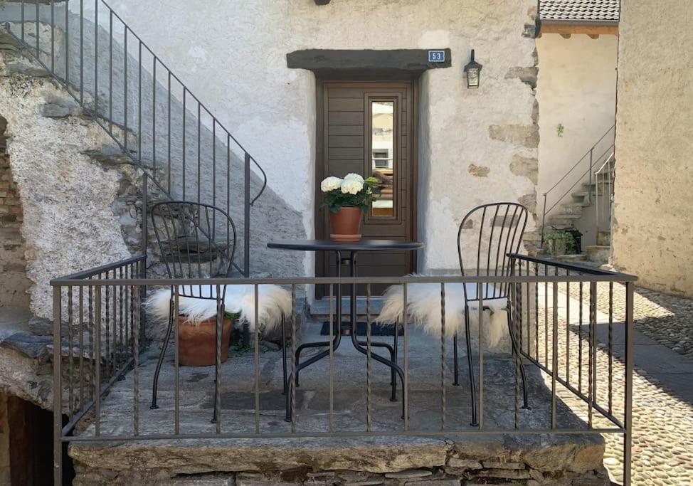 una mesa y sillas con dos perros sentados alrededor en Rustico Lucy, en Gordola