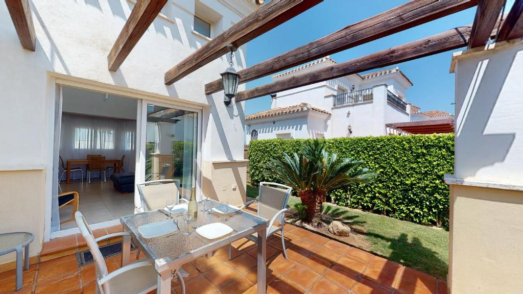 ein Esszimmer mit einem Tisch und Stühlen auf einer Terrasse in der Unterkunft Casa Quisqueya - A Murcia Holiday Rentals Property in Roldán