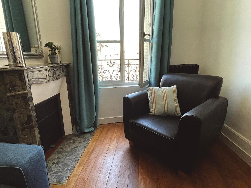 a living room with a chair and a window at Appartement cosy et lumineux centre-ville #4 in Dreux