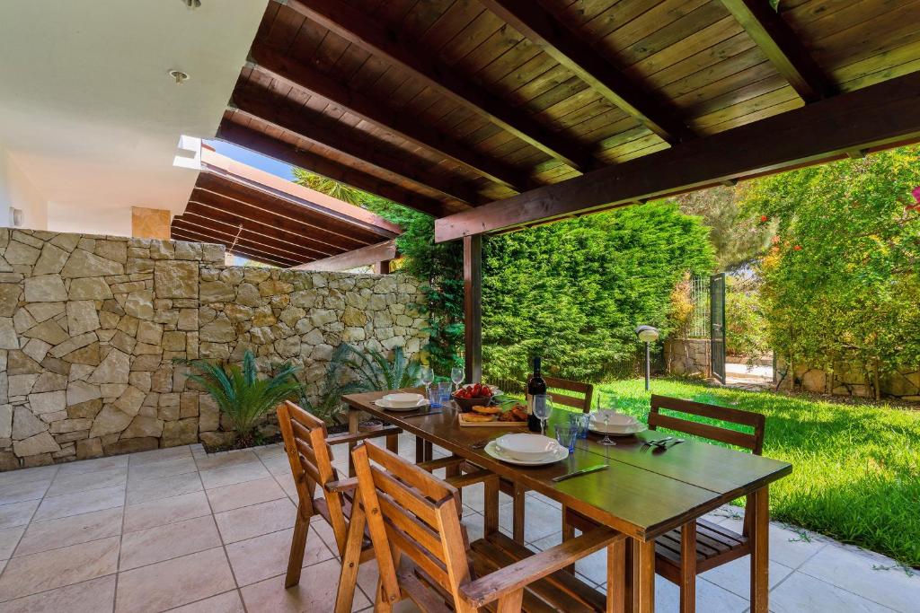 Torre InserraglioにあるVilla Selvaggia by BarbarHouseの石壁のパティオ(テーブル、椅子付)