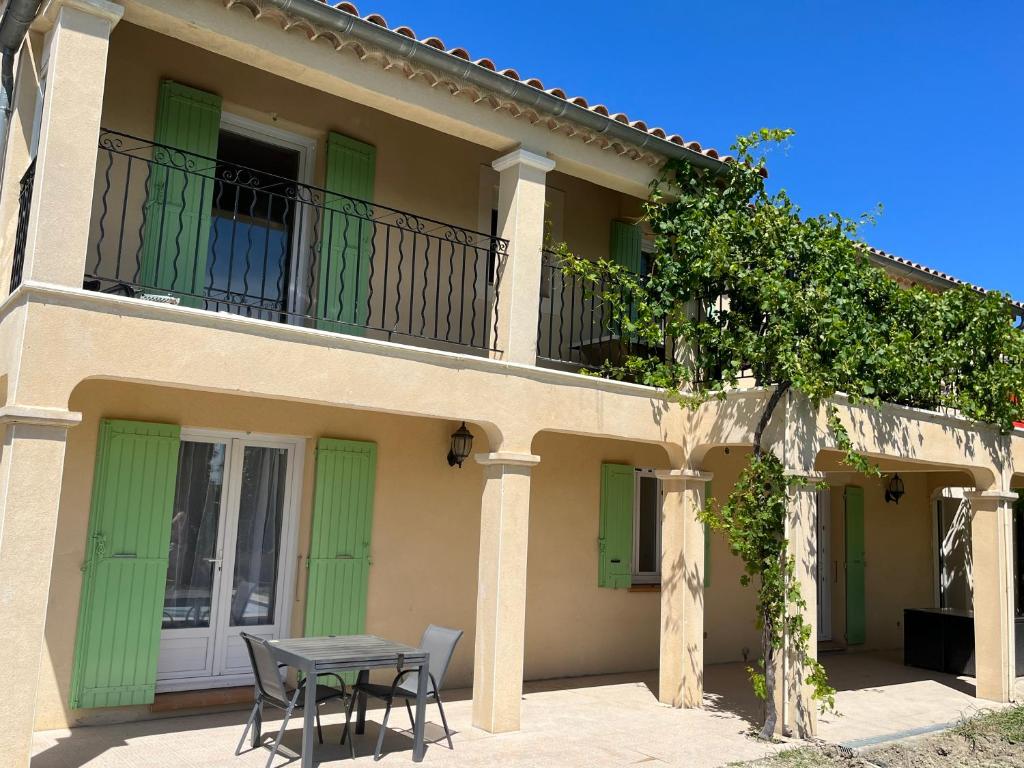 ein Haus mit einem Tisch und einem Balkon in der Unterkunft Villa Provençale in Beaumes-de-Venise