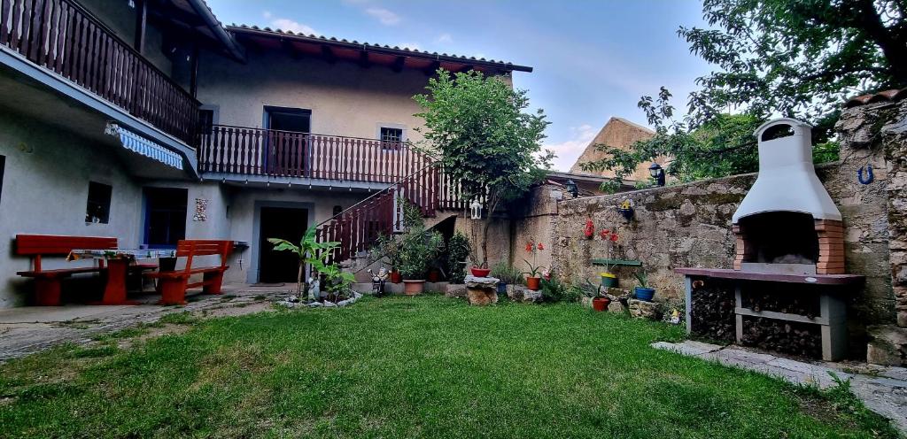 a yard with a stone building with a fireplace at Apartma Aria&Karra in Komen