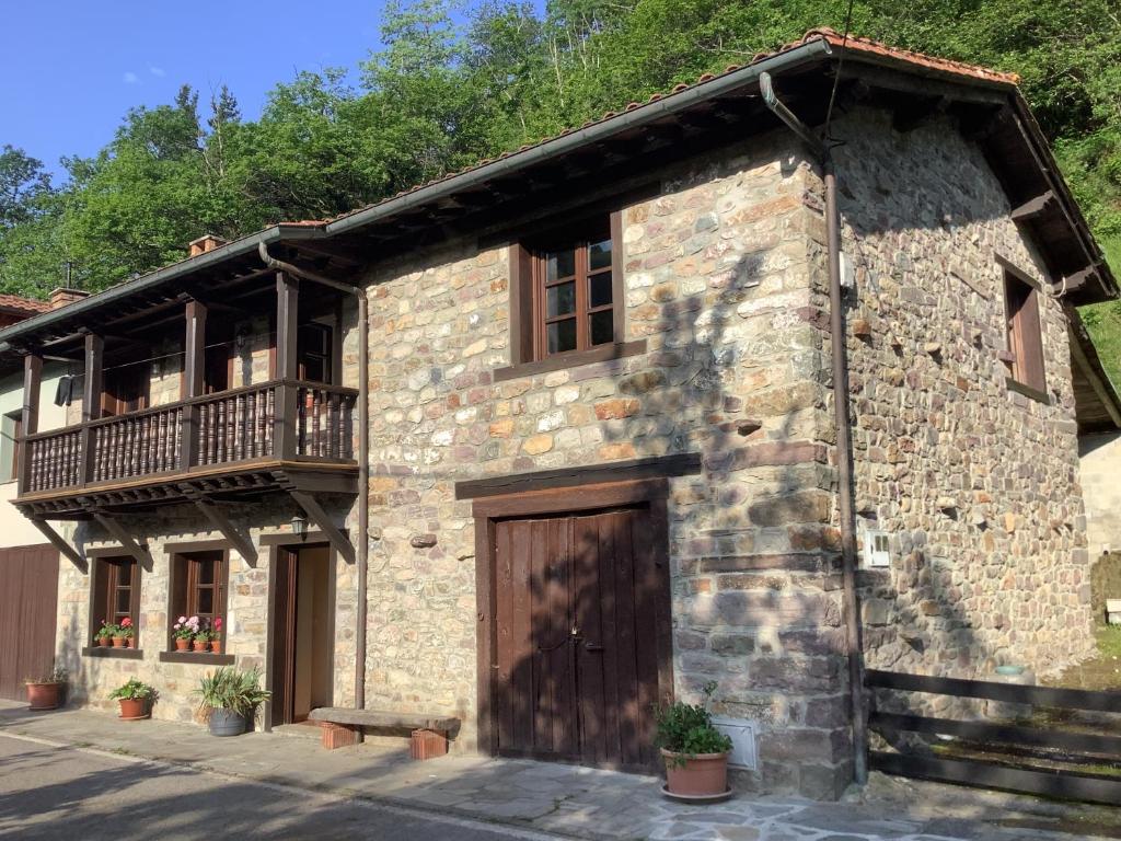 - un bâtiment en pierre avec un balcon et une porte en bois dans l'établissement Saja. The living mountain, 