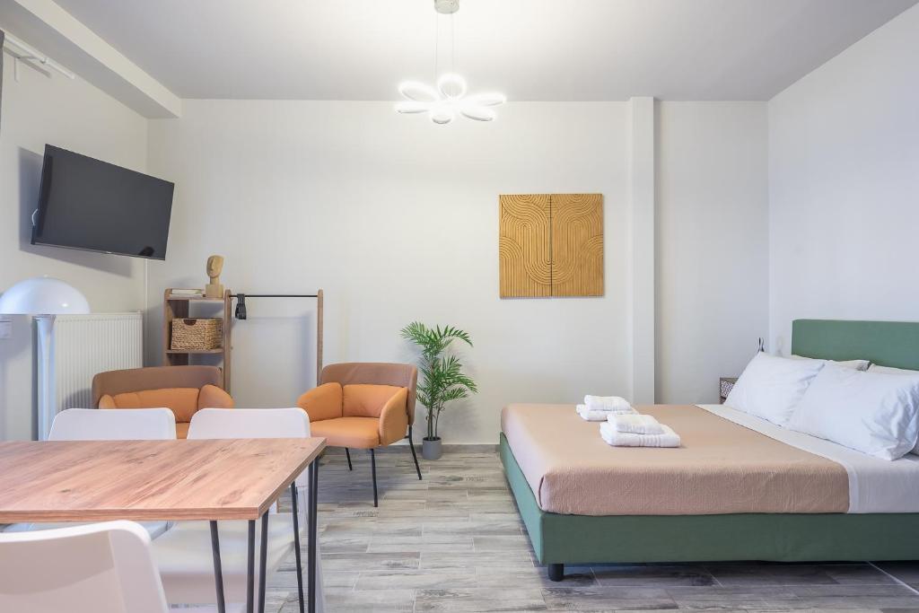 um quarto com duas camas e uma mesa e cadeiras em Sunny studio with Starlight balcony em Atenas