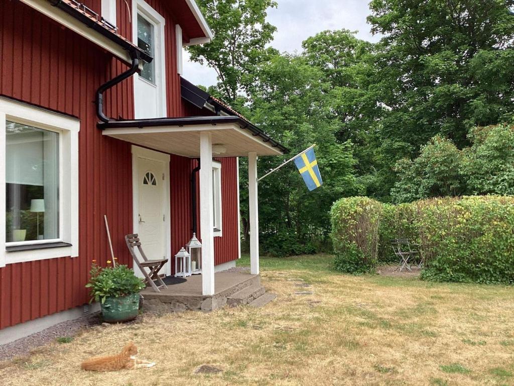 a flag flying on the porch of a red house at Holiday home MOTALA VI in Motala
