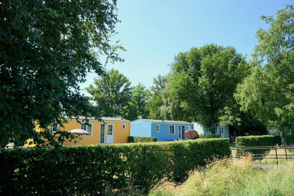 a row of houses in a yard with trees at Recreatiepark De Lucht in Renswoude