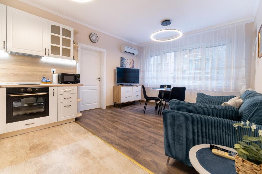 uma sala de estar com um sofá e uma cozinha com uma mesa em City center 2-Bedroom Apartment em Plovdiv