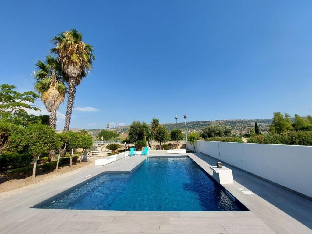 een zwembad in een villa met een palmboom bij Il sentiero delle palme in Comiso