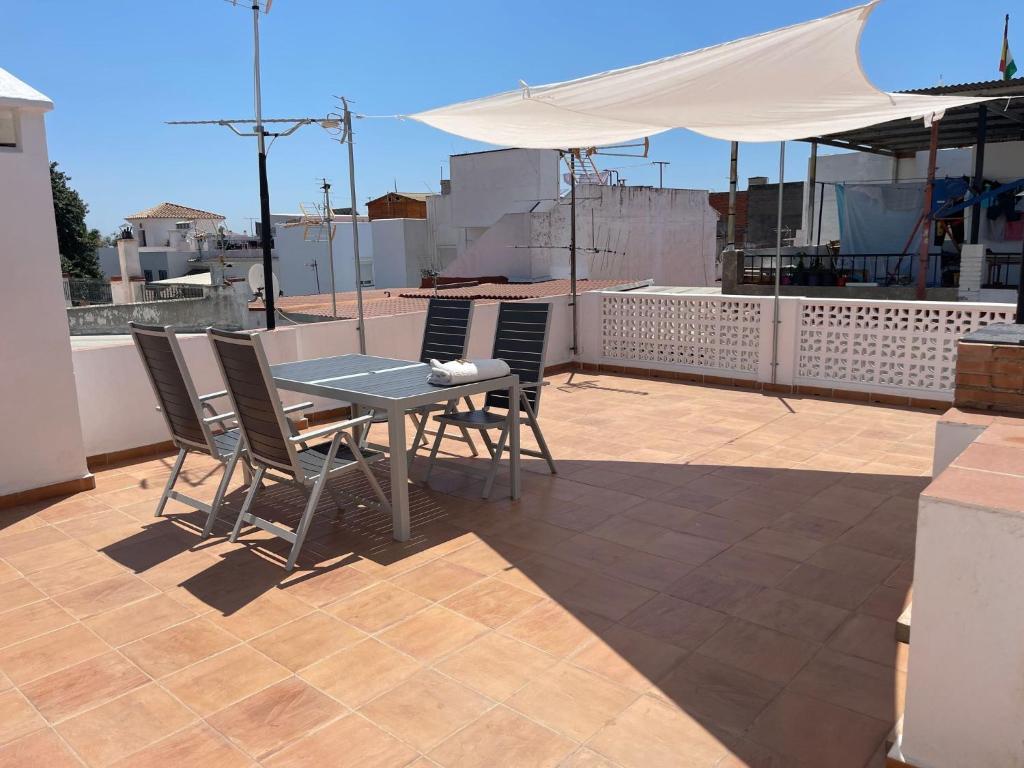 une table et des chaises sur un toit avec un parasol dans l'établissement Casa Calderón, à Marbella