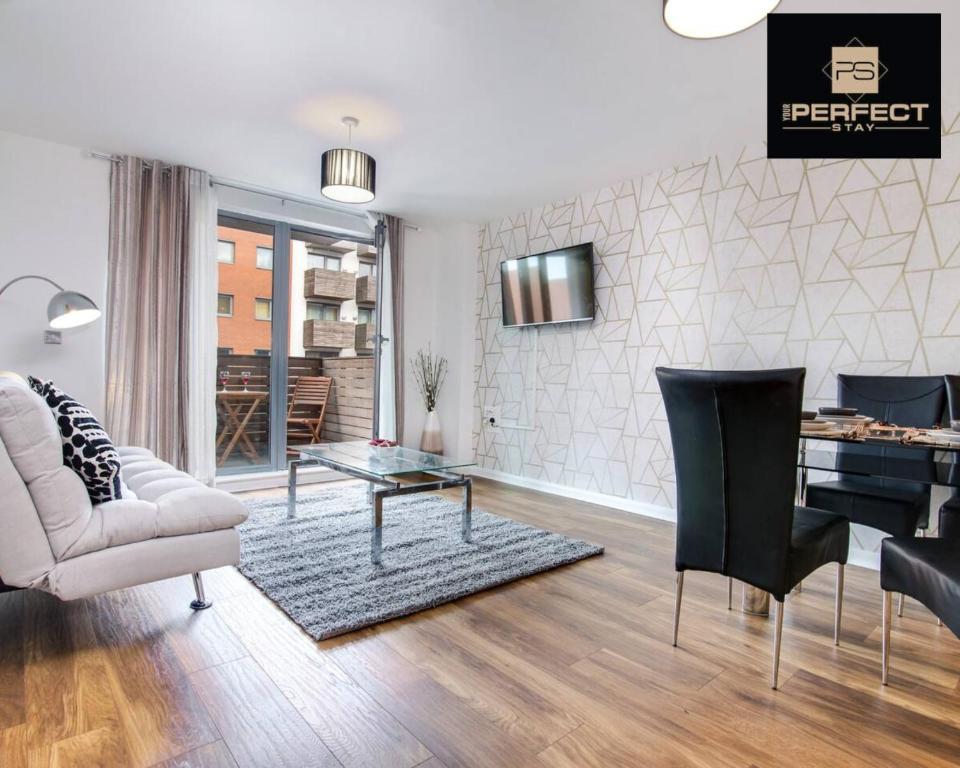 バーミンガムにあるElite residence Skyline By Your Perfect Stay Short Lets Birminghamのソファとテーブルと椅子のあるリビングルーム
