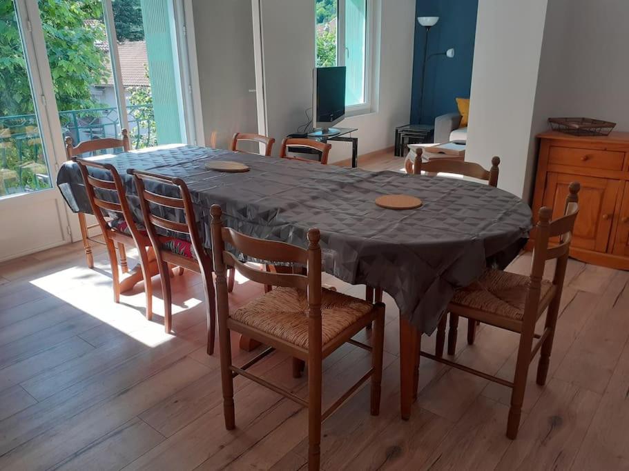 mesa de comedor con sillas y mantel negro en Loue appartement duplex de 90m2 refait à neuf, en Villefort