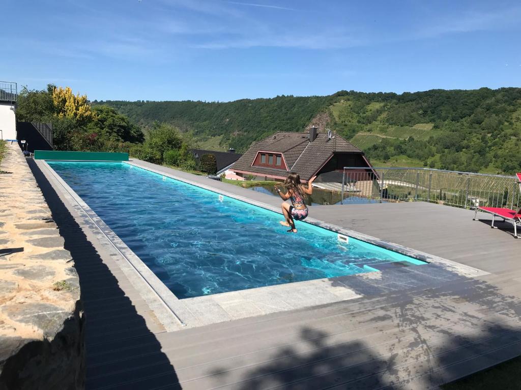 a woman jumping into a swimming pool at Rieslingresidenz in Traben-Trarbach