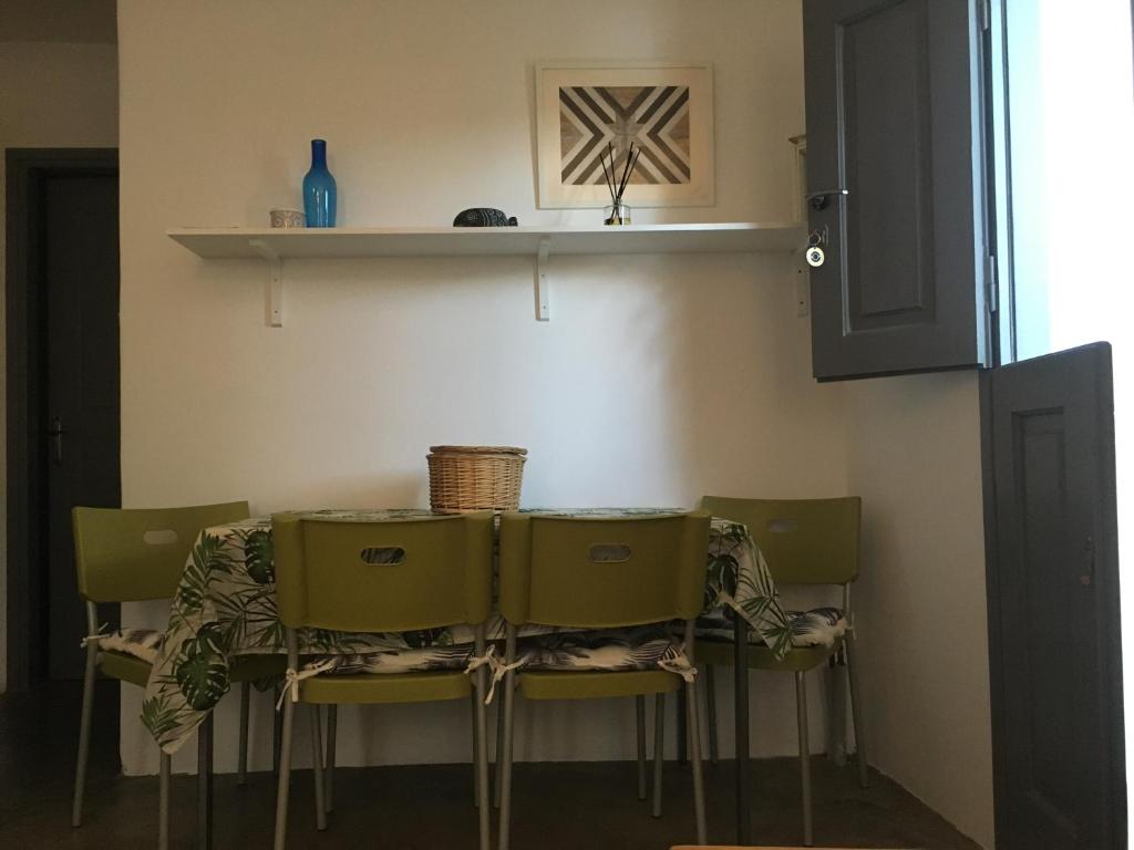 a dining room table with chairs and a shelf at Cristi Rooms in Livadi
